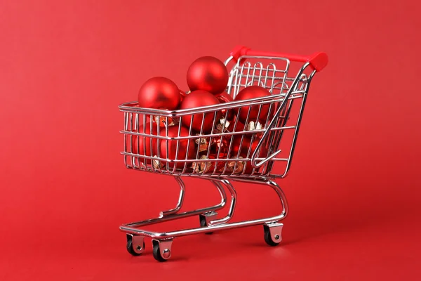 Cesta completa de compras de bolas de Natal matt vermelho e brilhante no fundo vermelho — Fotografia de Stock