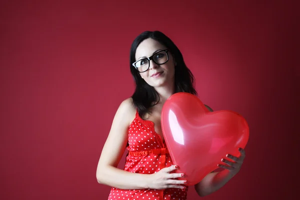 Sexig kvinna i röda underkläder med två ballonger formen hjärta på röd bakgrund alla hjärtans dag — Stockfoto