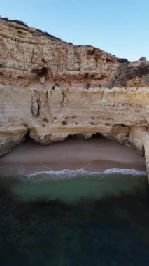 Portekiz 'in güney bölgesindeki Algarve' deki Praia da Marinha 'nın insansız hava aracı görüntüsü. Zührevi uçurum ve inanılmaz bir smerald suyu olan doğal kemerler. Yüksek kalite 4k görüntü