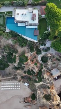 Güneş doğarken güzel Praia dos Tres Irmaos plajının turkuaz okyanus ve manzaralı uçurumlar, Portimao, Portekiz insansız hava aracı görüntüsü. Yüksek kalite 4k görüntü