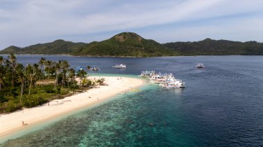 Filipinler 'de Coron ve El Nido arasındaki muhteşem Cagdanao Adası' nın insansız hava görüntüsü. Sahilde bekleyen voleybol ve bankalarla oynanan güzel kumlu ve mavi renkler. Bu, Coron 'dan yapılan keşif sırasında bir duraktı.