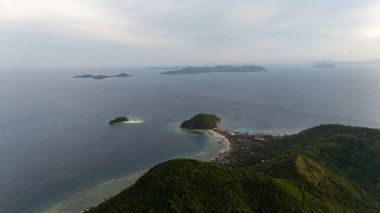 Bayang Basecamp ya da Calibangan Kampı 'nın insansız hava aracı görüntüsü ve Calibangbangan Adası kıyısı boyunca Coron ve El Nido, Palawan, Filipinler arasında turkuaz resifi. Bu, Coron ve El Nido ile Büyük D arasındaki keşif gezisinin temel direktörlerinden biriydi.