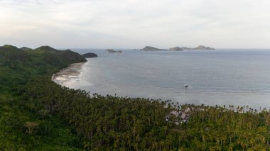 Bayang Basecamp ya da Calibangan Kampı 'nın insansız hava aracı görüntüsü ve Calibangbangan Adası kıyısı boyunca Coron ve El Nido, Palawan, Filipinler arasında turkuaz resifi. Bu, Coron ve El Nido ile Büyük D arasındaki keşif gezisinin temel direktörlerinden biriydi.