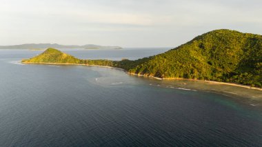 Bayang Basecamp ya da Calibangan Kampı 'nın insansız hava aracı görüntüsü ve Calibangbangan Adası kıyısı boyunca Coron ve El Nido, Palawan, Filipinler arasında turkuaz resifi. Bu, Coron ve El Nido ile Büyük D arasındaki keşif gezisinin temel direktörlerinden biriydi.