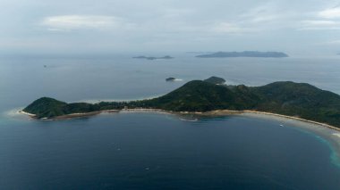 Bayang Basecamp ya da Calibangan Kampı 'nın insansız hava aracı görüntüsü ve Calibangbangan Adası kıyısı boyunca Coron ve El Nido, Palawan, Filipinler arasında turkuaz resifi. Bu, Coron ve El Nido ile Büyük D arasındaki keşif gezisinin temel direktörlerinden biriydi.