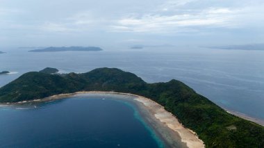 Bayang Basecamp ya da Calibangan Kampı 'nın insansız hava aracı görüntüsü ve Calibangbangan Adası kıyısı boyunca Coron ve El Nido, Palawan, Filipinler arasında turkuaz resifi. Bu, Coron ve El Nido ile Büyük D arasındaki keşif gezisinin temel direktörlerinden biriydi.
