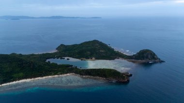 Bayang Basecamp ya da Calibangan Kampı 'nın insansız hava aracı görüntüsü ve Calibangbangan Adası kıyısı boyunca Coron ve El Nido, Palawan, Filipinler arasında turkuaz resifi. Bu, Coron ve El Nido ile Büyük D arasındaki keşif gezisinin temel direktörlerinden biriydi.