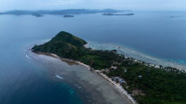 Bayang Basecamp ya da Calibangan Kampı 'nın insansız hava aracı görüntüsü ve Calibangbangan Adası kıyısı boyunca Coron ve El Nido, Palawan, Filipinler arasında turkuaz resifi. Bu, Coron ve El Nido ile Büyük D arasındaki keşif gezisinin temel direktörlerinden biriydi.
