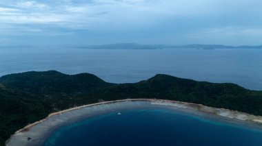 Bayang Basecamp ya da Calibangan Kampı 'nın insansız hava aracı görüntüsü ve Calibangbangan Adası kıyısı boyunca Coron ve El Nido, Palawan, Filipinler arasında turkuaz resifi. Bu, Coron ve El Nido ile Büyük D arasındaki keşif gezisinin temel direktörlerinden biriydi.