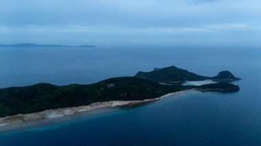 Bayang Basecamp ya da Calibangan Kampı 'nın insansız hava aracı görüntüsü ve Calibangbangan Adası kıyısı boyunca Coron ve El Nido, Palawan, Filipinler arasında turkuaz resifi. Bu, Coron ve El Nido ile Büyük D arasındaki keşif gezisinin temel direktörlerinden biriydi.