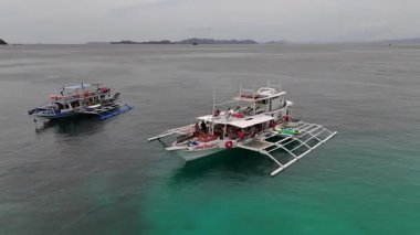 Filipinler 'de Coron ve El Nido arasındaki muhteşem Cagdanao Adası' nın insansız hava görüntüsü. Sahilde bekleyen voleybol ve bankalarla oynanan güzel kumlu ve mavi renkler. Big Dream Boatman 'la yaptığımız keşif sırasında....