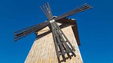 Mavi gökyüzüne karşı eski ahşap yel değirmeni. Yel değirmeni yelkenleri. Kırsal arkaplan.