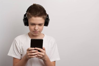 Tabletli ve kulaklıklı bir çocuk en sevdiği müziği müzik listesinden seçer.