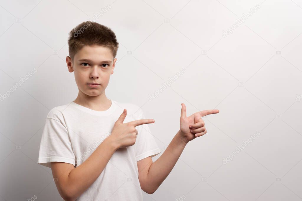 A teenager points with his fingers at an imaginary thing during a fashion photoshoot