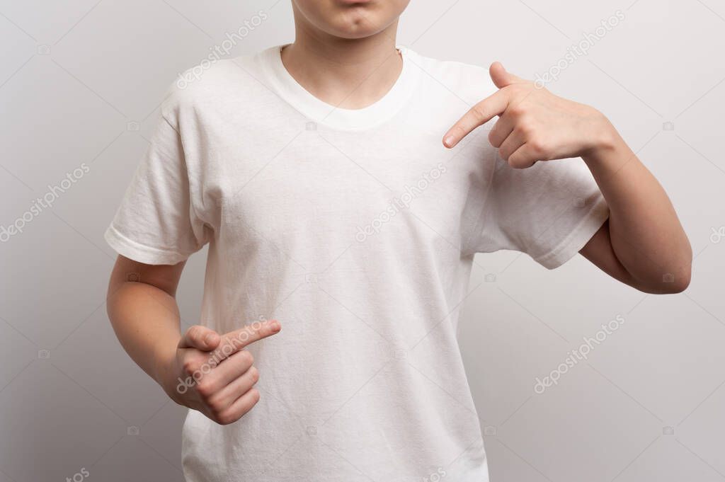 A teenager points with his fingers at an imaginary thing during a fashion photoshoot