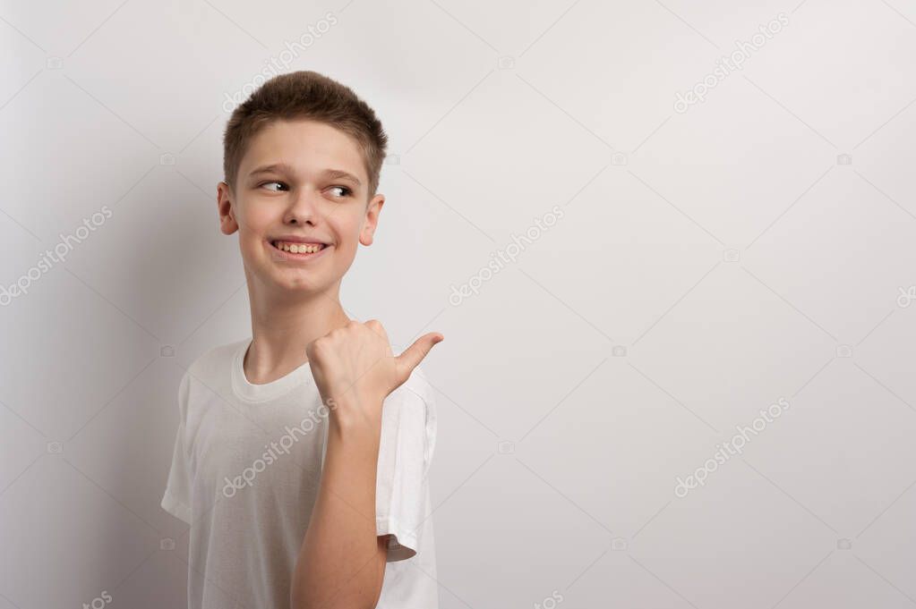 A teenager points with his fingers at an imaginary thing during a fashion photoshoot