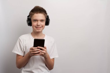 Tabletli ve kulaklıklı bir çocuk en sevdiği müziği müzik listesinden seçer.