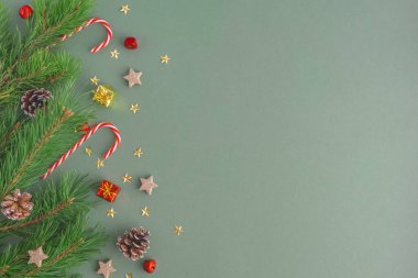 Noel arkaplanı köknar dalları, Noel oyuncakları, koniler, lolipoplar ve yazı için yeri olan yıldızlar. Yeşil arkaplan