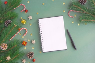 Ağaçlardan, oyuncaklardan ve Noel şekerlemelerinden yapılmış bir Noel arkaplanda bir kalem. Yeni yıl planları, tebrikler. Model