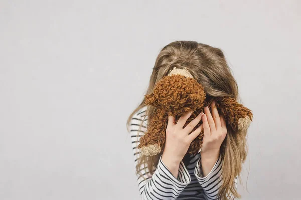 Üzgün liseli kız, genç kız yüzünü oyuncak ayıya gömmüş. Gençlik depresyonu, intihara meyilli düşünceler, ebeveynleri yanlış anlama. Ruh Sağlığı.