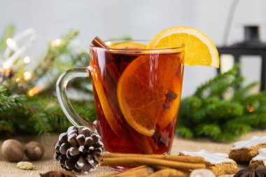 Bir bardak sıcak şarap, taze portakal dilimleri ve tarçın çubuğuyla yılbaşında sıcak şarap. Noel, sıcak kış içeceği.