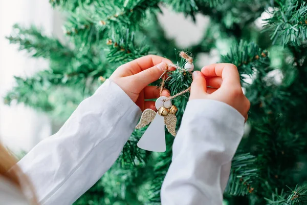 Detailní záběr dívky ruku obléká s dřevěnými hračkami, anděl vánoční stromek. Ekologické vánoční hračky — Stock fotografie
