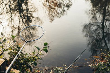 Balıkçılık ve eğlence konsepti. Doğadaki hobi. Çuval, olta ya da batan güneşin ışınlarında gölde dönme.