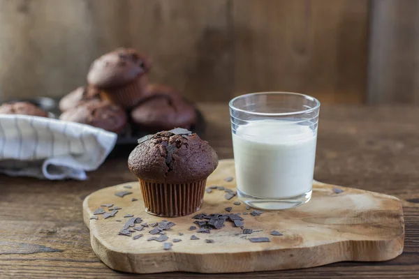 Hembakade nybakade muffins bredvid ett glas mjölk på en rustik träbakgrund. Frukost. Färskt bageri — Stockfoto