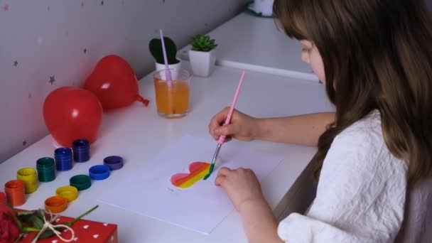 かわいい女の子が虹色にハートを描きます。愛のシンボル。スローモーション — ストック動画