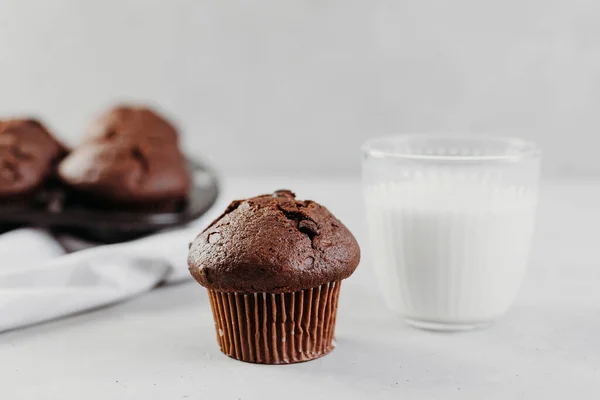 Hemgjorda chokladmuffins eller tårta med ett glas mjölk. Plats för text. Hembakade bakverk eller bakverk till frukost eller fest — Stockfoto