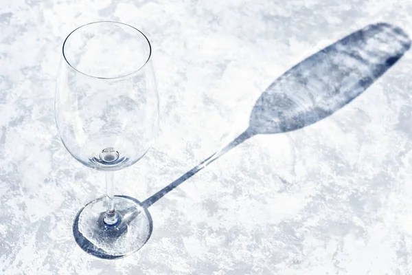 Ein Glas Wein auf grauem Betongrund mit harten Schatten. Sonniger Tag — Stockfoto