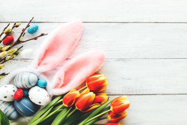 Paskalya, bahar, renkli yumurtalar, kırmızı lale çiçekleri, tavşan kulakları ve söğüt dallarıyla bezenmiş. Boşluğu kopyala