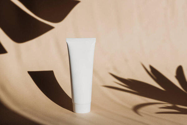 Косметический летний макет. Банка, трубка со сливками на бежевом фоне с твёрдыми тенями. Летний уход за кожей. Фонды SPF