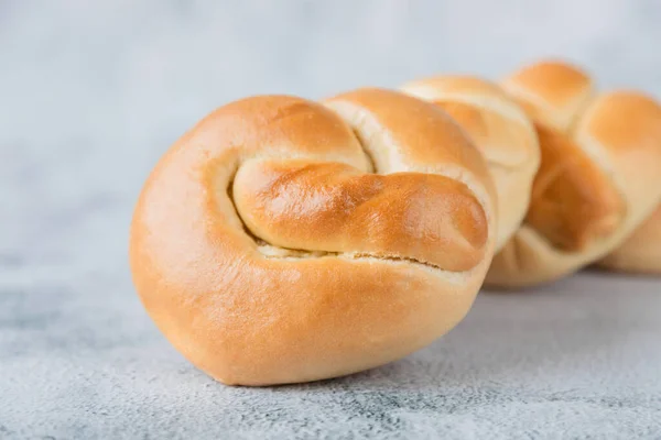 Close-up van verse broodjes op een houten plank. Zelfgemaakte taarten, brood maken, bakkerij. — Stockfoto