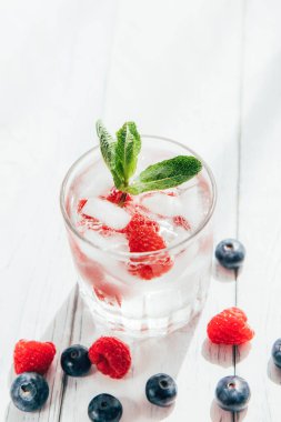 Taze böğürtlen, buz ve bir tutam nane ile ferahlatıcı içecek. Yaz içkileri. Dikey fotoğraf. Boşluğu kopyala