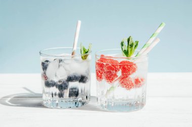 İki bardak soğuk limonata, dutlu su, pastel arka planda kokteyl tüpleri. Uzayı kopyala Sıcakta içkileri tazeliyorum.