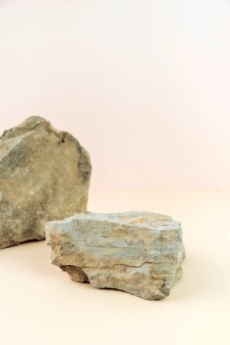 Pastel arka planda ürün sergilenmesi için taş podyum. Reklam için ideal bir model. Dikey fotoğraf.