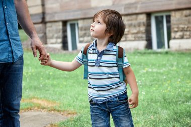 Babam oğullarının elini tutuyor. Okula dönelim. Oğlan çocuk anaokuluna gidiyor. Ebeveyn bakımı, ebeveynlik. Ebeveynler ve çocuklar arasındaki ilişki. Çocuklar korkar.