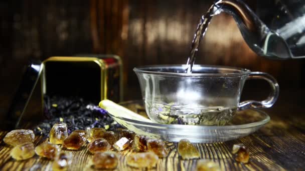 Infuser le thé dans une tasse en verre sur un fond en bois — Video