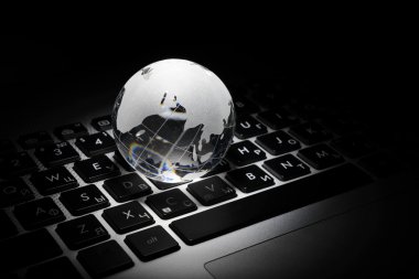 bir dizüstü bilgisayar klavye üzerinde bir cam dünya iş kavramı