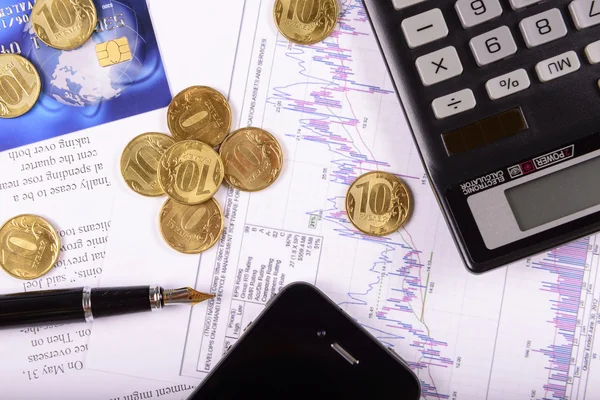 Business composition of the coins, calculator and charts — Stock Photo, Image