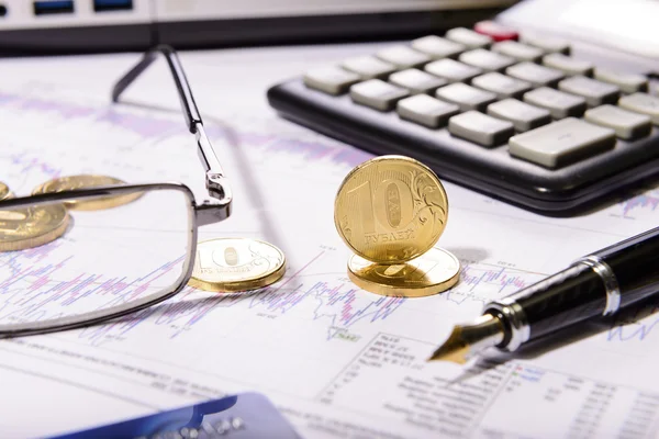 Business composition of the coins, calculator and charts — Stock Photo, Image