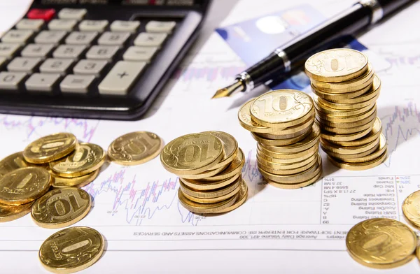 Business composition of the coins, calculator and charts — Stock Photo, Image