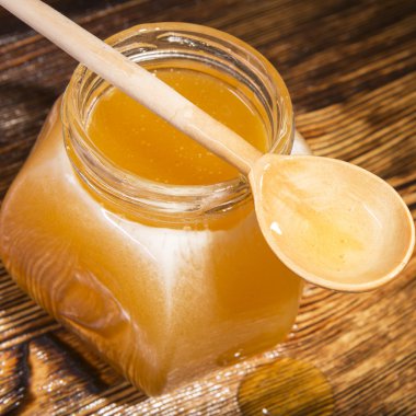 Bal ve bir ahşap zemin üzerine kaşık kavanoz