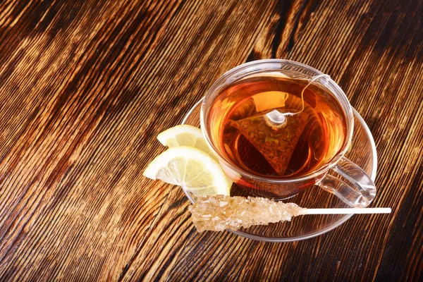 Чашка чая с лимоном на деревянном фоне — стоковое фото