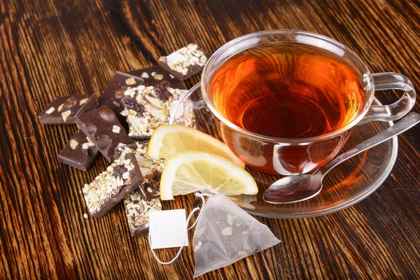 Чашка чая с лимоном на деревянном фоне — стоковое фото
