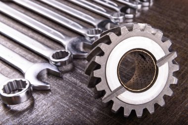 gear wheel and wrenches on a metal background clipart