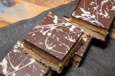 Lezzetli bir yığın milyoner çikolatalı kekler ve şekerli şekerlemeler ahşap bir masada.