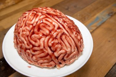 Çilek kaynaklı beyin şeklinde bir pasta, sünger kekini cadılar bayramı partisi çölü için gerçek bir insan beyni gibi göstermek için fırçaladı.