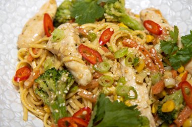 Mutfakta beyaz bir kasede lezzetli bir fırında zencefil ve fıstık tavuklu şehriye tabağı.